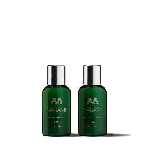 Two bottles of MASAMI branded hair care products, one labeled as shampoo and the other as conditioner, with a dark green color and silver caps.