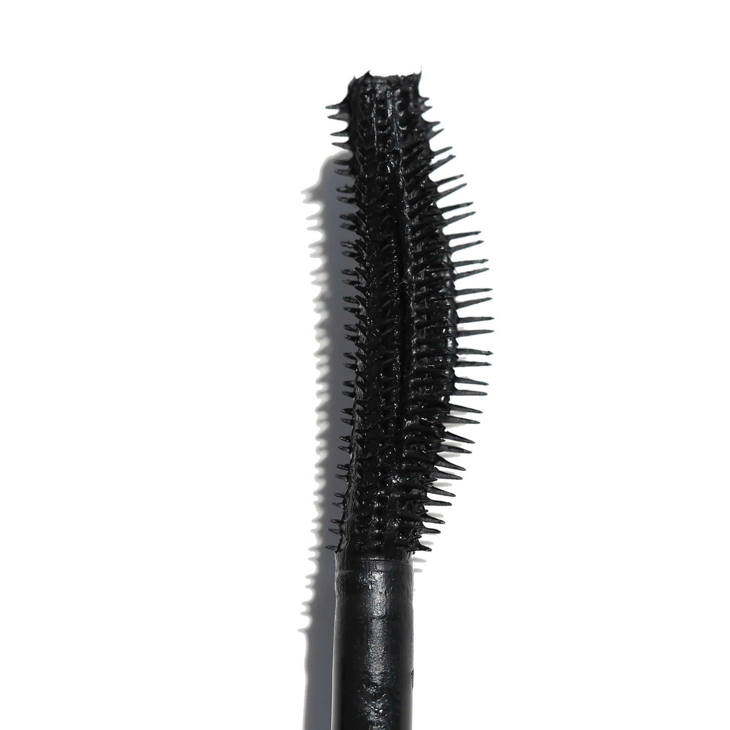 Close-up of the curved wand of the Night Show Volumizing Mascara featuring fine bristles for precise application.