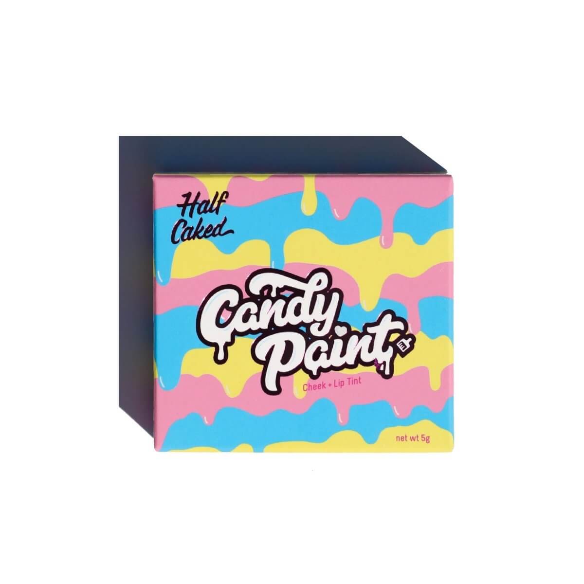 Colorful packaging of Candy Paint Cheek + Lip Tint by Half Caked with vibrant drip design in pink, blue, yellow, and white.