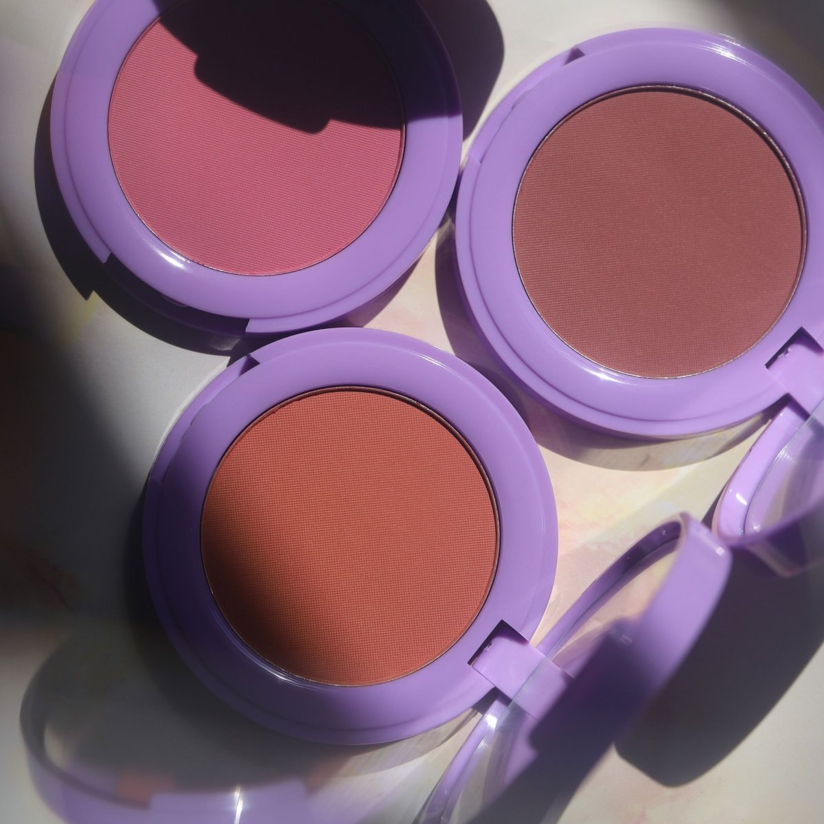 purple compact with brown orange and pink pan -In Bloom Powder Blush - Half Caked