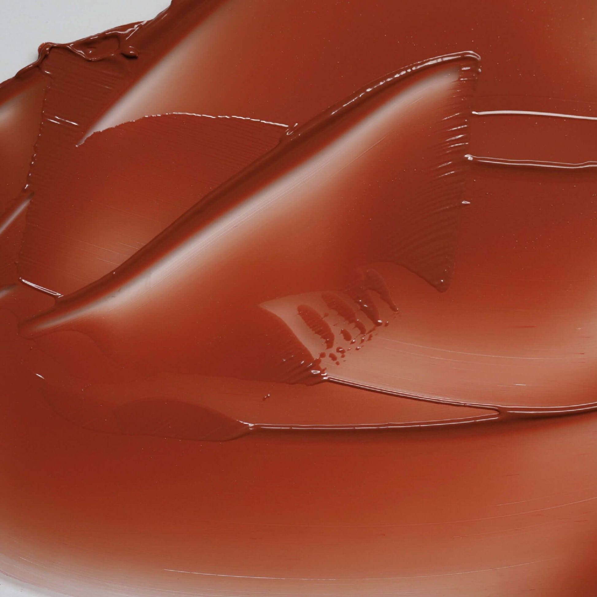 Close-up texture of Candy Paint Cheek + Lip Tint in a warm shade, highlighting its creamy and blendable properties with a dewy finish.