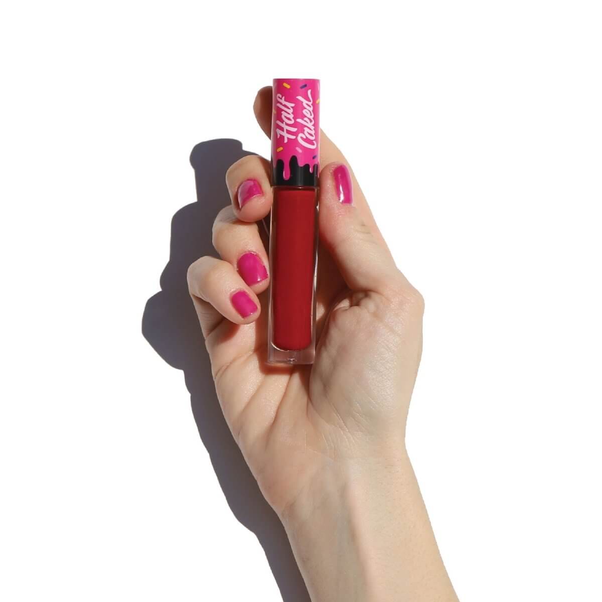 Hand with pink nail polish holds a red lip with pink cap -Lip Fondant Liquid Lipstick - Half Caked